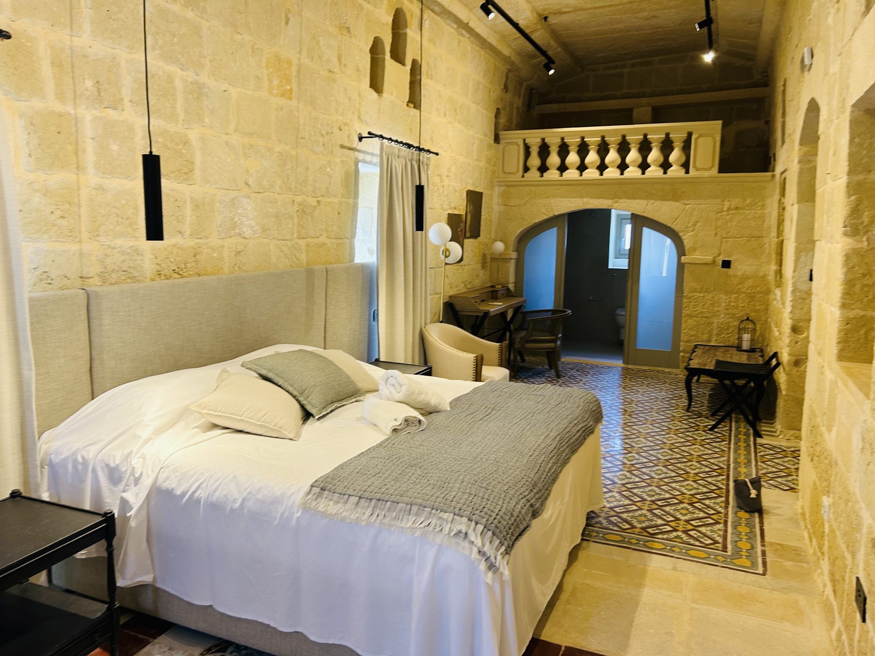 Spacious bedroom with stone walls and tiled floor
