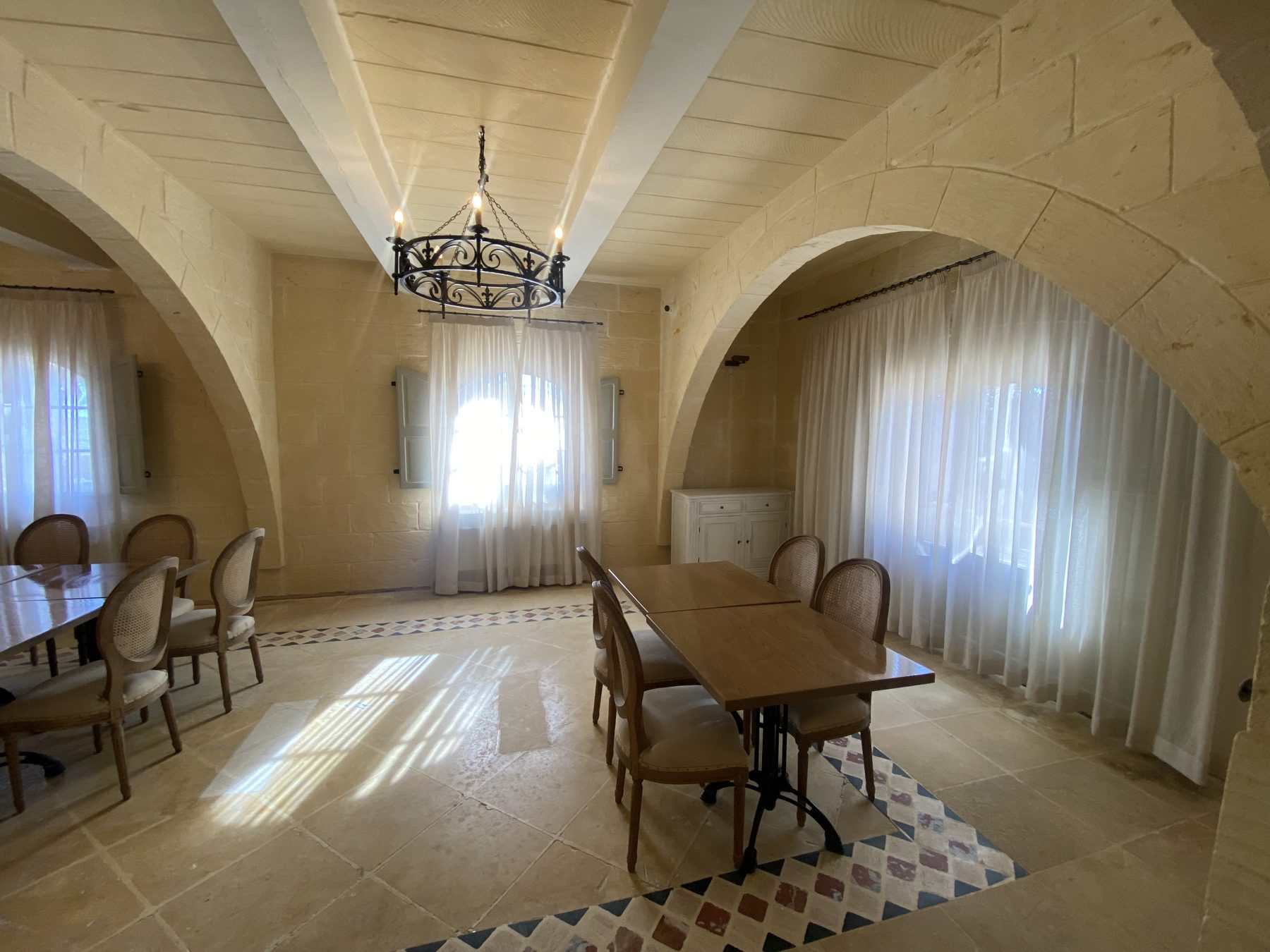 Dining room under stone arches with sheer curtains